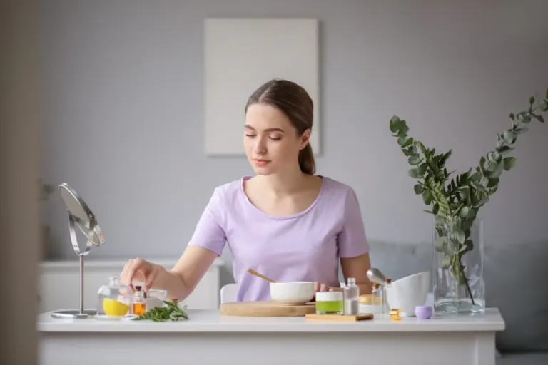 Person blending cosmetic ingredients in a bowl at a table