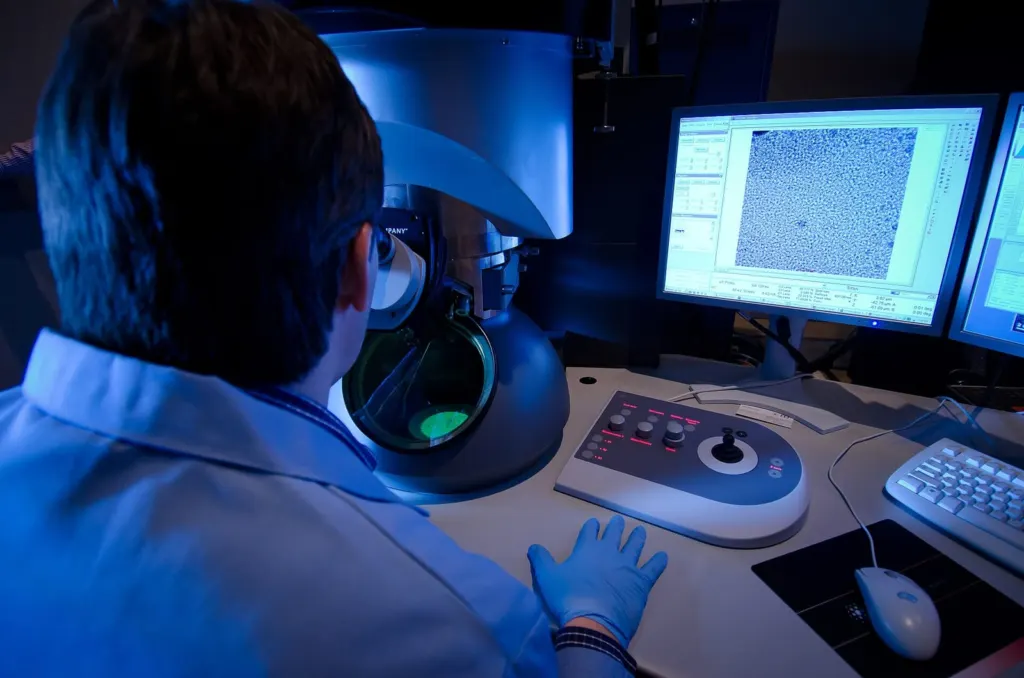 Researcher reviewing image data on screens in a darkened laboratory