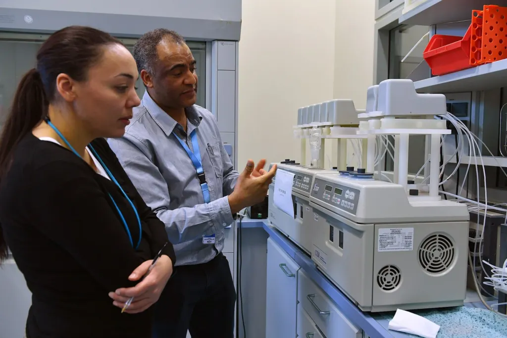 Two scientists reviewing an analytical instrument in a laboratory