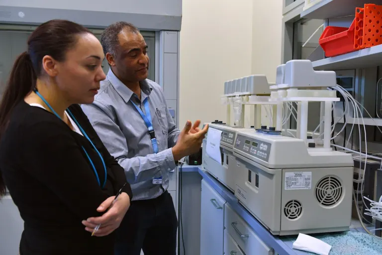 Two scientists reviewing an analytical instrument in a laboratory