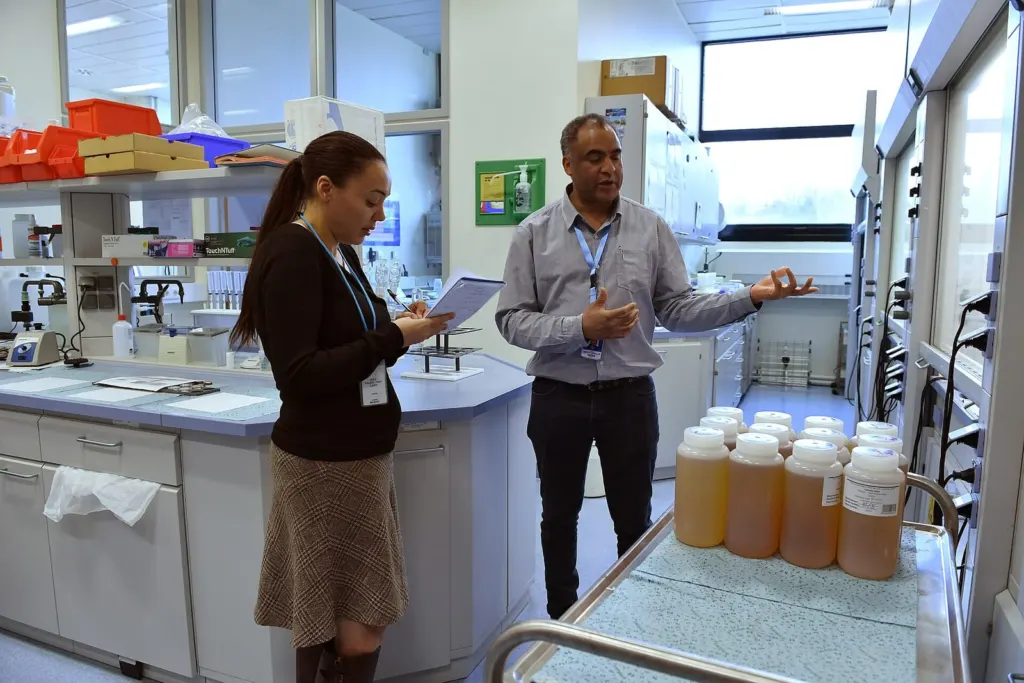 Two colleagues reviewing notes while walking through a laboratory