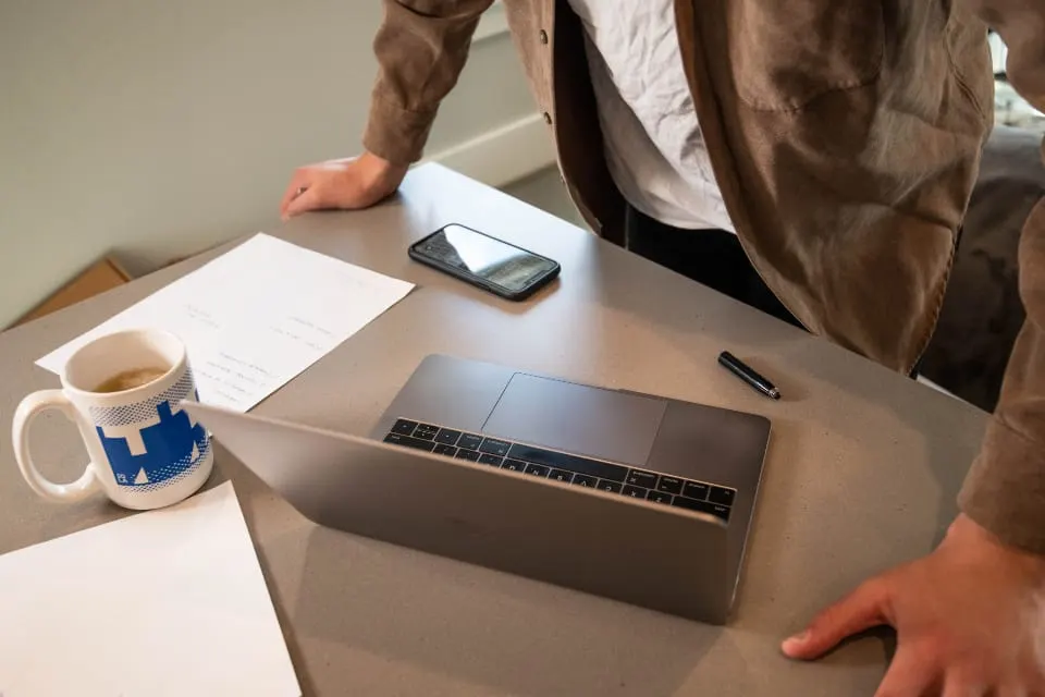 Colleagues working with a laptop and printed documents