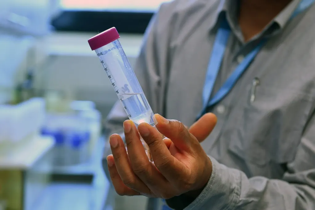 Analyst holding a labelled sample tube in a laboratory